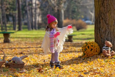 Sonbahar ormanında ayısıyla küçük bir kız.