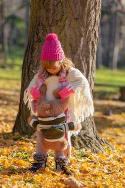 Sonbahar ormanında ayısıyla küçük bir kız.