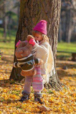 Sonbahar ormanında ayısıyla küçük bir kız.