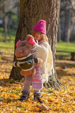 Sonbahar ormanında ayısıyla küçük bir kız.
