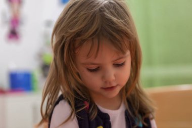 Evde oynarken tatlı bir kızın yüzündeki ifadeler.