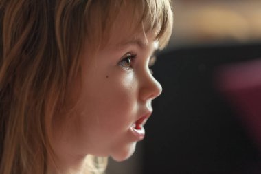 Çizgi film ararken profilden bir çocuğun görüntüsü, alanın derinliğine dikkat edin