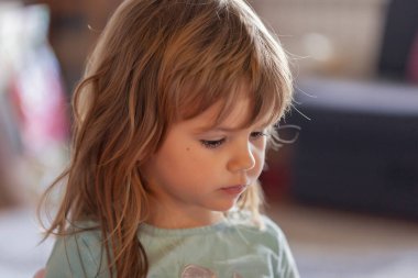 Küçük kız evdeki kaseden dondurma yiyor.