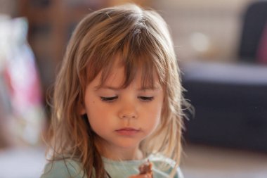 Küçük kız evdeki kaseden dondurma yiyor.