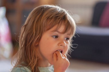 Küçük kız evdeki kaseden dondurma yiyor.