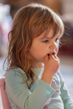 Küçük kız evdeki kaseden dondurma yiyor.