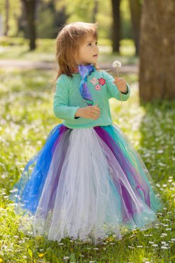 Kız karahindiba üflerken doğada poz veriyor.