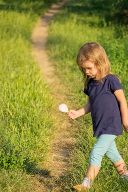 Çimenlerde dondurması olan bir çocuk
