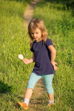 Çimenlerde dondurması olan bir çocuk