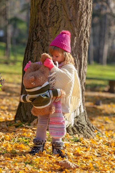 Sonbahar ormanında ayısıyla küçük bir kız.