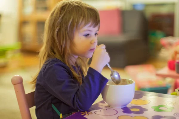 Bambina Mangiare Biscotti Latte Mentre Guarda Cartone Animato — Foto Stock