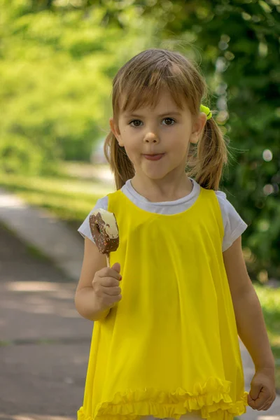 Uma Menina Vestido Amarelo Lambendo Sorvete Natureza — Fotografia de Stock