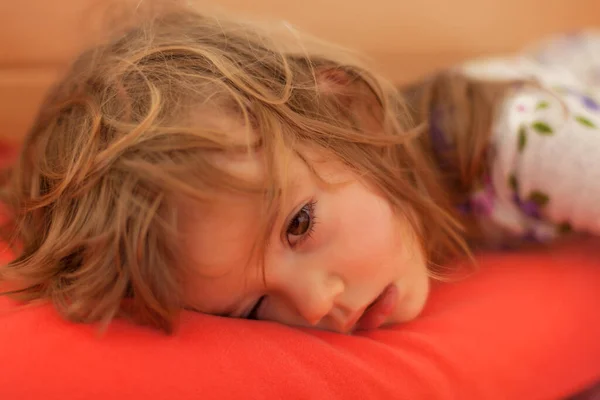 小女孩睡在大床上 注意浅浅的田野 免版税图库照片
