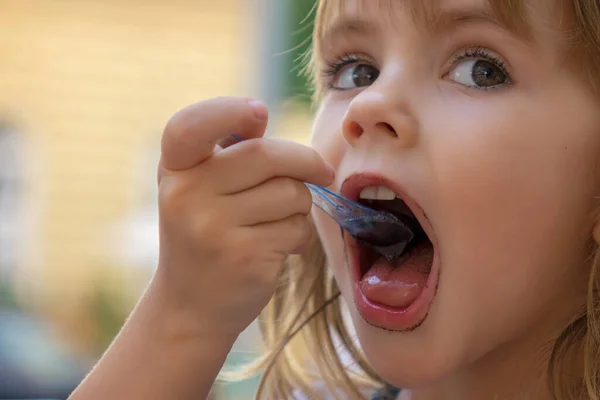 カップからアイスクリームを食べる少女 ストック写真