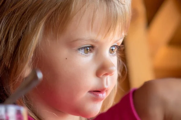 A girl\'s face expression while eating ice cream in close-up