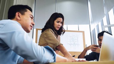 İnşaat alanında genç Asyalı mimarlardan oluşan bir ekip tartışıyor..