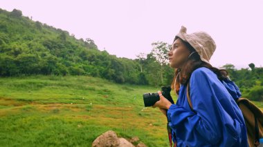 Genç bayan gezgin dağdaki manzaranın tadını çıkarın.