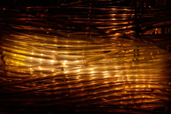 Siyah arkaplanda sarmalanmış ışık hortumu.