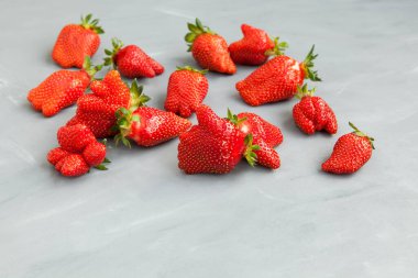 Çirkin meyveler. Anormal çilek şekli. Gri arka planda olgun böğürtlenler. Seçici odak, boşluğu kopyala.