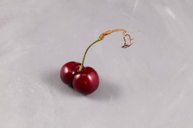 Gri arka planda komik taze erimiş kiraz. Kavram - çirkin meyve ve sebze yemek. Yiyecek atıklarının azaltılması.