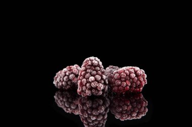 Karanlık bir arka planda donmuş böğürtlenler. Yakın çekim, metin için yer.