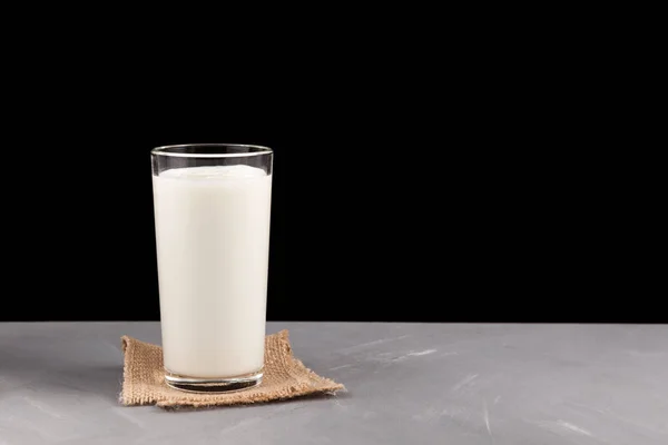 Ayran or kefir in a glass on a dark background. Fermented milk ayran. Milk diet for weight loss. Selective focus. Place for text.