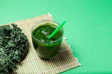 Yeşil arka planda lahana yapraklı taze organik sebze suyu. Sağlıklı içecek alternatif tıpta da kullanılır. Seçici odak, boşluğu kopyala.