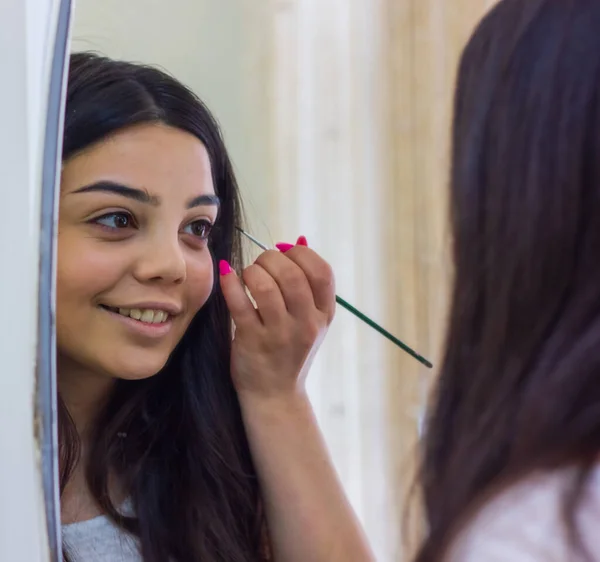 Ung Kvinde Der Anvender Mascara Kvinde Der Anvender Fyldes Kvinde - Stock-foto