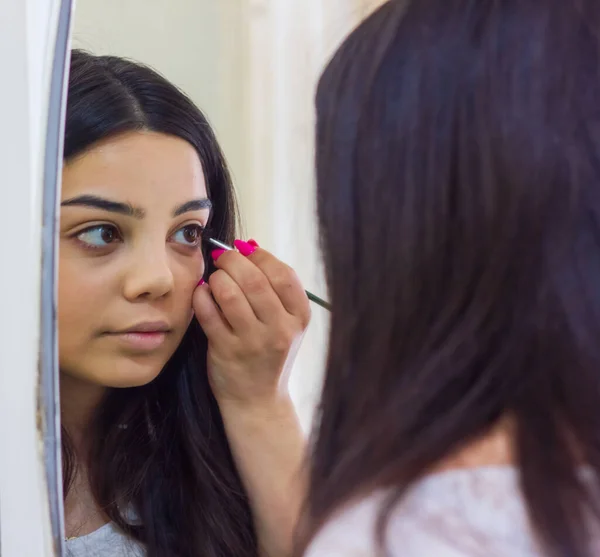 Ung Kvinde Der Anvender Mascara Kvinde Der Anvender Fyldes Kvinde - Stock-foto