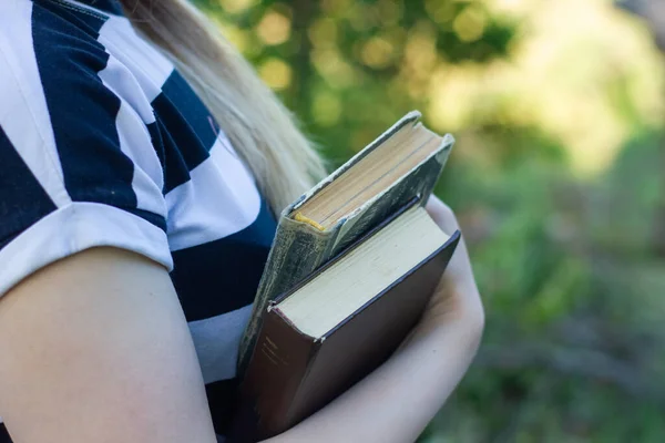 young girl with books in the garden