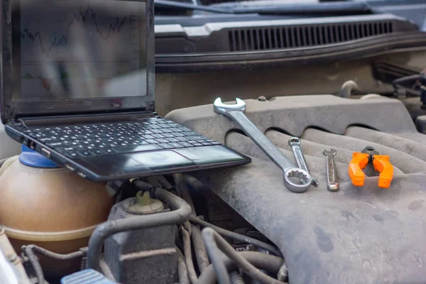 車のエンジンの診断用の黒いノートパソコン — ストック写真