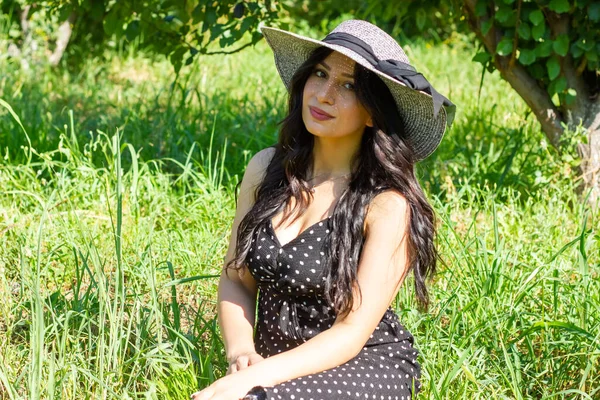 Junge Frau Mit Strohhut Sitzt Auf Dem Gras Garten — Stockfoto