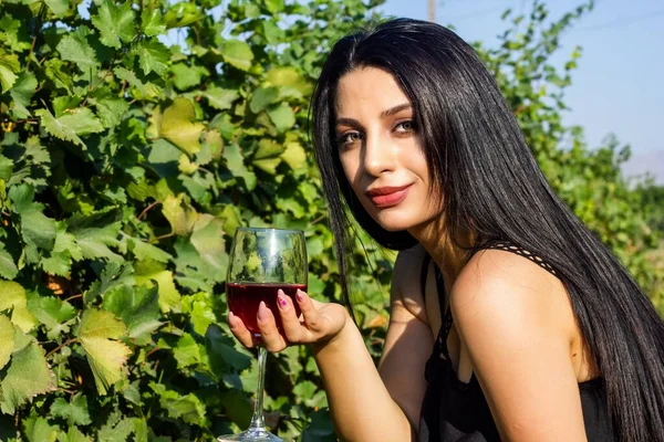 pretty woman in vineyard drinking wine