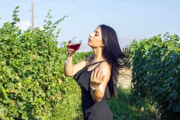 pretty woman in vineyard drinking wine