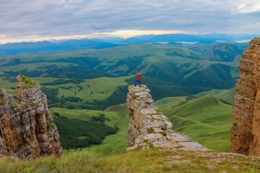 Drone havadan gelen görüntüleyin. Adam güneş doğarken Bermamyt Kuzey Kafkasya plato üzerinde amfitiyatro bir kaya üzerinde duruyor.