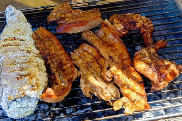 Barbecue of pork, chicken and fish is fried on the grill on the — Stock Image Barbecue of pork, chicken and fish is fried on the grill on the Stock Picture