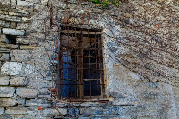 An old window in a stone house on a street in Varenna, a small town on lake Como, Italy