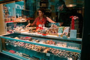 ANTWERP, BELGIUM - 2 Ekim 2019: Bilinmeyen kişiler Antwerp 'teki bir pastaneden Belçika şekerleri satın alıyor