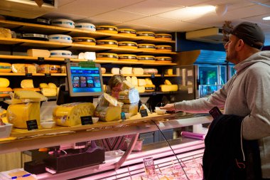 Amsterdam, Hollanda, Avrupa, 11 Ekim 2019. Bilinmeyen biri Hollanda 'daki Amsterdam peynir dükkanından peynir alıyor. Çeşitli geleneksel Hollanda peynirleri indirimde.