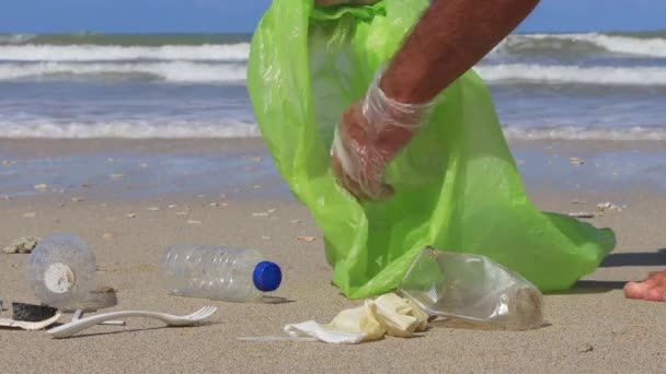 从海滩捡塑料垃圾塑料瓶 塑料袋 稻草和杯子散落在原始的海滩上 环境清理 — 图库视频影像