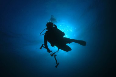 Mavi denizin derinliklerindeki dalgıcın sualtı fotoğrafı.