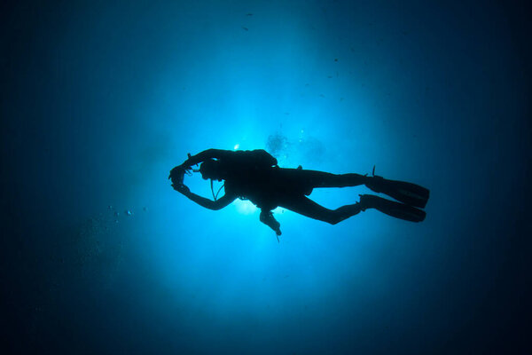 подводная фотография водолаза в глубине синего моря