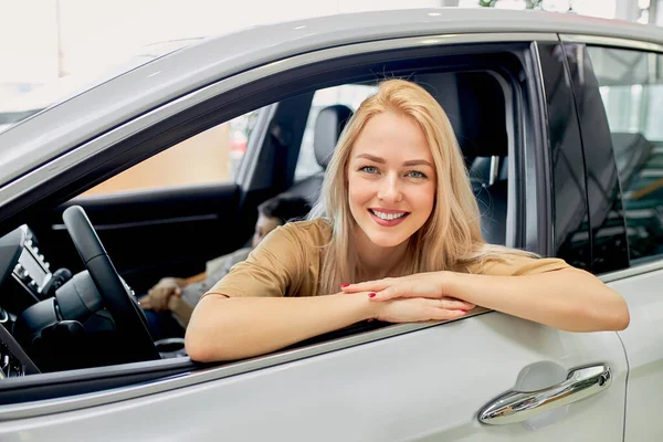 Sorridente senhora dentro de carro na concessionária — Fotografia de Stock