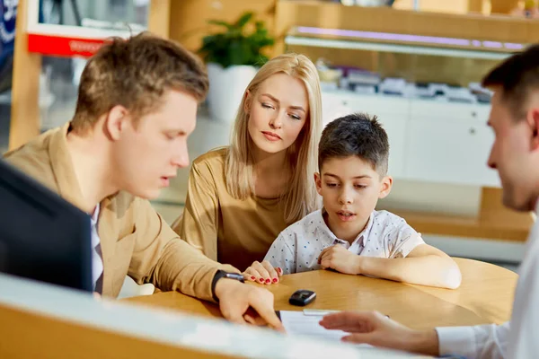 young caucasian family read documents and talk with consultant before purchase