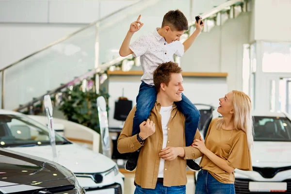 El chico más feliz del mundo con padres en la concesionaria — Foto de Stock