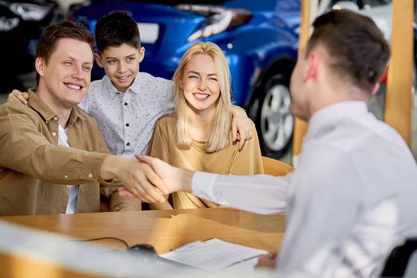 Trevliga kunder skakar hand med lyhörd konsult av bilar återförsäljare — Stockfoto