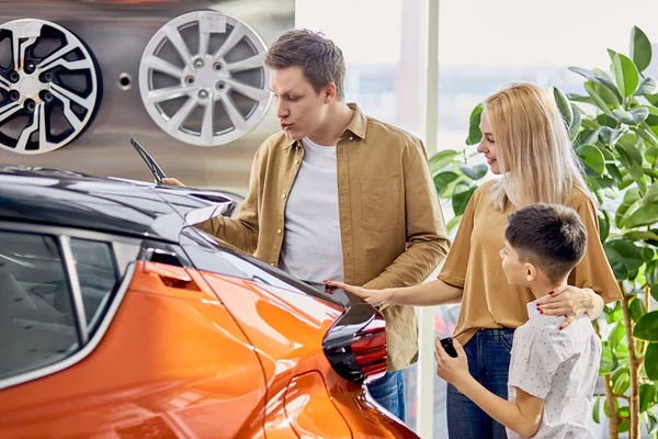 Vamos a comprar este coche. familia en el concesionario — Foto de Stock