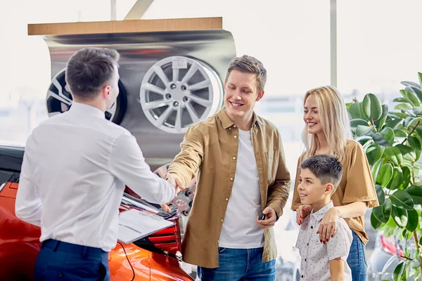 Trevliga kunder skakar hand med lyhörd konsult av bilar återförsäljare — Stockfoto