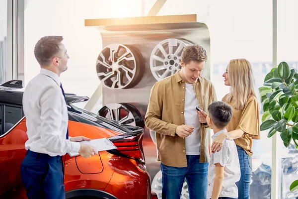 Feliz familia caucásica ahora los propietarios de nuevo hermoso coche — Foto de Stock