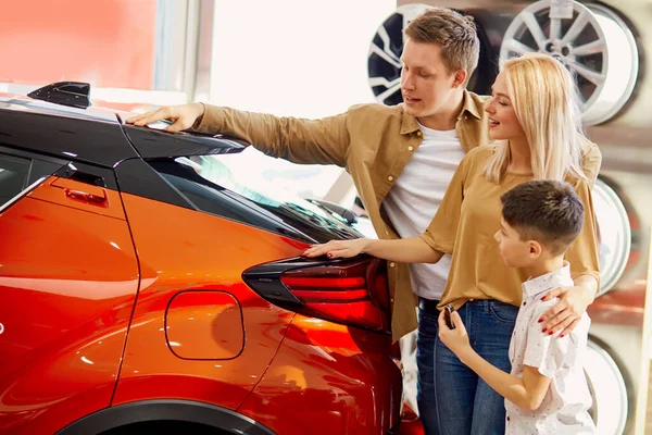 Uma jovem família com um filho gostava de um certo carro — Fotografia de Stock